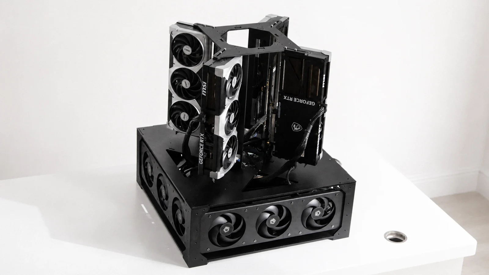 Open-frame four-GPU professional AI workstation concept with stacked graphics cards, exposed motherboard, and a lower cooling plenum with three fans.